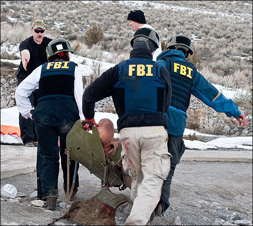 Students carry a casualtyon a litter.