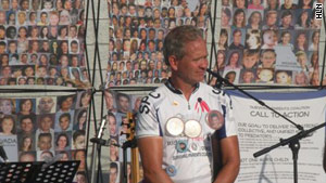 Ed Smart, whose daughter was kidnapped, addresses the crowd. Behind him are photos of victimized children.